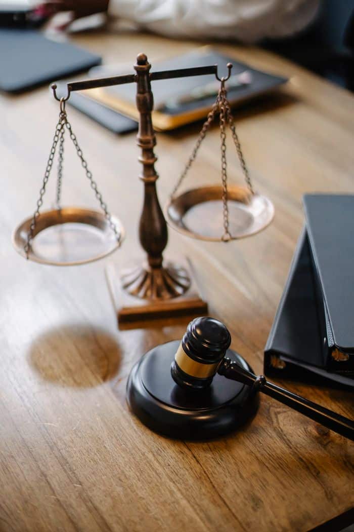 about-img High angle lawyers desk with decorative judgement scales and gavel in modern law firm