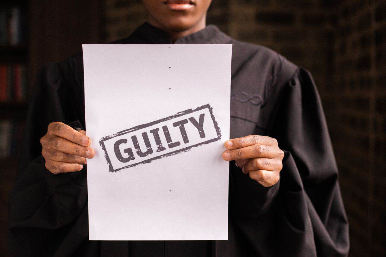 home-img A judge in a courtroom holding a paper with a guilty verdict, symbolizing law and justice.